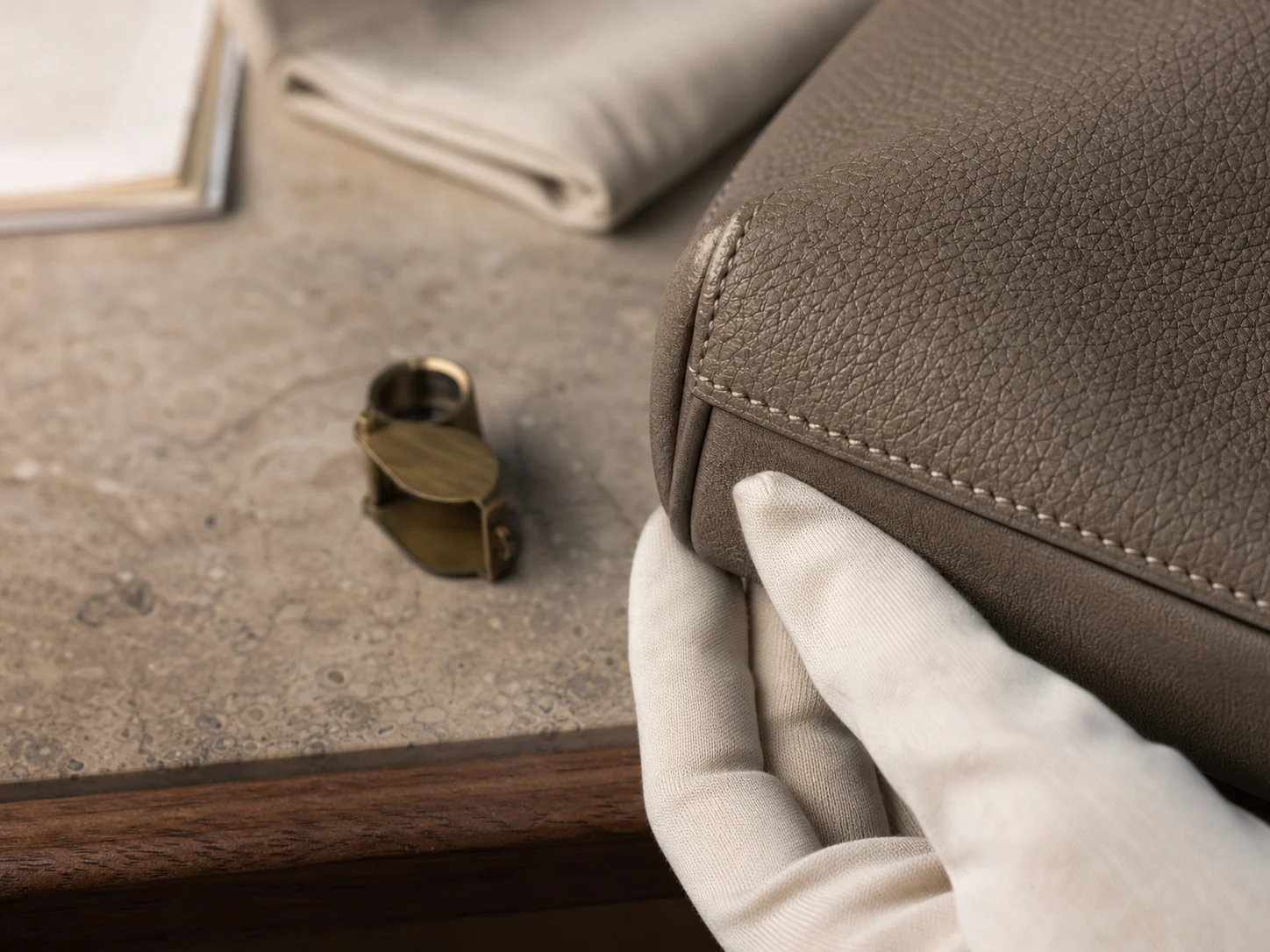 Close-up of a specialist inspecting leather grain and stitching